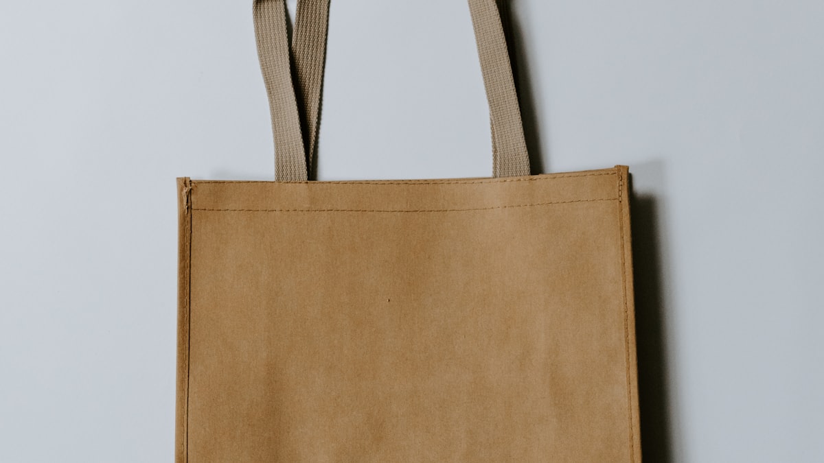 Sacola de compras de papel kraft vazia apoiada em uma parede clara